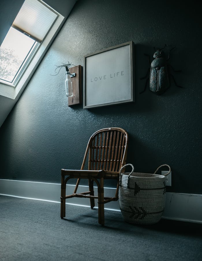 Charming minimalist interior featuring a wooden chair, framed art, and natural light.